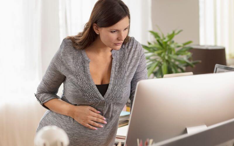 kobieta w ciąży przy komputerze